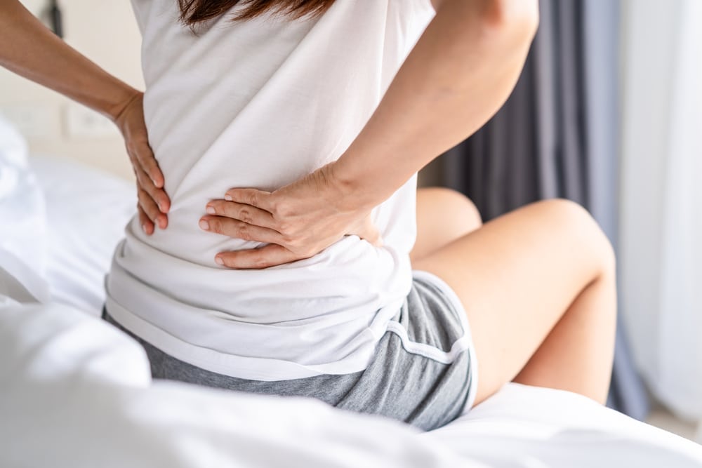Doctor examining a patient's back and spine for possible nerve injury to protect future nerve function.